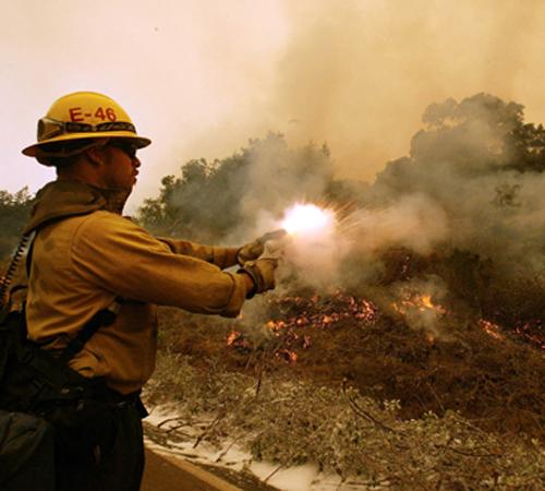 Firefighter Vince Felix, of Santa Barbara, Calif., shoots a flare gun unto a hillside during a backburn operation on Highway 1 in Big Sur, Calif., on Sunday. Firefighters continue to fight the Basin Complex Fire in the Los Padres National Forest near Big Marcio Jose Sanchez, The Associated Press
