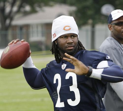 Chicago Bears return specialist Devin Hester throws the ball as wide receivers coach Darryl Drake looks on during training camp at Olivet Nazarene University in Bourbonnais, Ill., on Friday. Hester was given a contract extension after a brief holdout that Charles Rex Arbogast, The Associated Press
