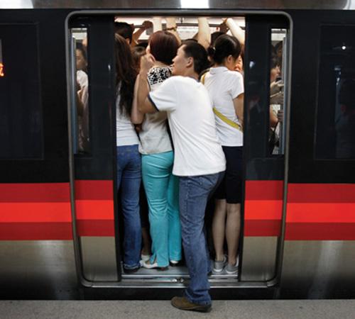 Commuters crowd a train at a subway station in Beijing on Monday. Many commuters switched to the subway on Monday, the first workday for restrictions on car use under a bold plan to clear the Olympic city of its notorious smog-choked skies. The Associated Press
