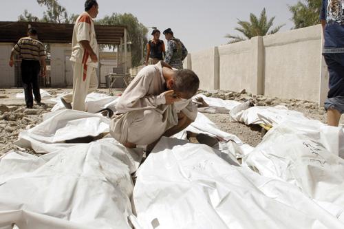 A man mourns next to bodies of victims of a suicide attack in Baqouba, 60 kilometers (35 miles) northeast of Baghdad, Iraq, on Tuesday. Two suicide bombers blew themselves up in a crowd of army recruits northeast of Baghdad on Tuesday, killing at least 2 The Associated Press
