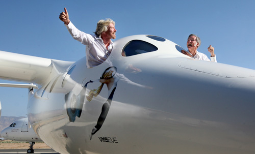 Sir Richard Branson, left, and Burt Rutan wave during an unveiling ceremony on Monday. The Associated Press
