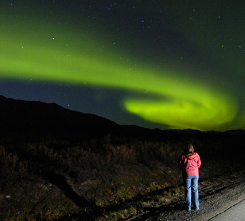 A spectator watches the aurora borealis rise above the Alaska Range on Sept. 3, 2006 in Denali National Park, Ala. On Thursday NASA released new findings on the northern lights. The Associated Press
