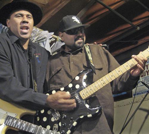 Blues musicians Ronnie Baker Brooks, left, and his brother, Wayne Baker Brooks, sons of blues legend Lonnie Brooks, perform in their basement on Feb. 12 in Dolton, Ill. Ronnie says the blues was more vibrant in the days when his father came to the Chicago Caryn Rousseau, The Associated Press
