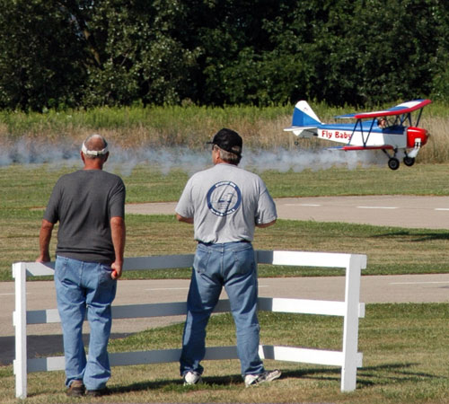 Model airplane enthusiasts watch Fly Baby come in for a close pass at the Champaign County Radio Control Club giant scale airplane fly-in on Sunday. Erica Magda
