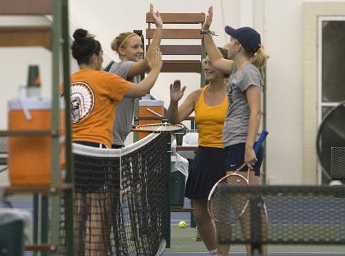 Past and present Illinois tennis players high-five after doubles match at the Alumni Reunion, Friday at Atkins Tennis Center. Erica Magda
