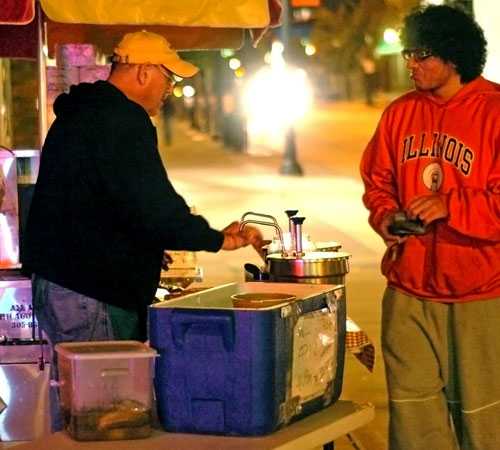 Hot dog vendor Dick Christenson sells hot dogs on Green and Sixth streets in Champaign on Monday. The charismatic business owner has run hot dog stands for 40 years, and also owns a restaurant in Danville Heights. Ramzi Dreessen
