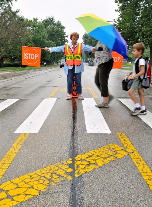 Crossing+guard+Rose+Hudson+helps+Leeann+Stack+and+her+son+Alex%2C+7%2C+across+Prospect+Street+in+Champaign+by+Bottenfield+Elementary+on+Thursday.+Erica+Magda%0A