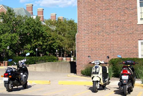 This photo shows scooters parked outside the Graduate Library on Tuesday afternoon. The fuel economy advantages of scooters are making them increasingly popular and an attractive option for getting around campus. Erica Magda
