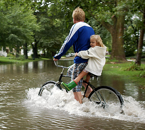 Lars Gustafson of Champaign, Ill., gives his daughter, Olivia, a ride through a flooded section of Park Ave. in Champaign on Sunday, Sept. 14, 2008. Rain flooded streets and buildings on Sunday. Erica Magda
