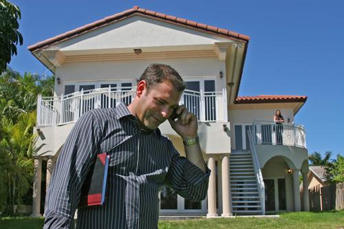Real estate agent Rick Milea fields calls during an open house to sell this $1.5 million home on the Intracoastal Waterway in Hollywood, Fla. on Saturday. Milea says business has increased now that foreclosures and forced sales have depressed housing pric Marianne Armshaw, The Associated Press
