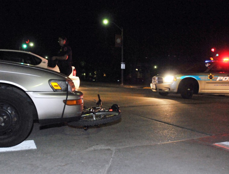 A University Police Department officer responds to a car-bicycle accident at the intersection of Sixth and Gregory Tuesday night. Claire Napier
