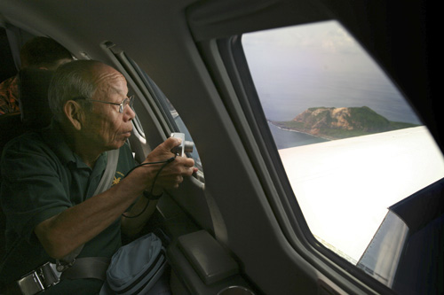 81-year-old Tsuruji Akikusa, a Japanese WWII veteran and survivor of the battle of Iwo Jima looks out the window of a U.S. military jet as he flies over the island and Mount Suribachi on Sept. 10. David Guttenfelder, The Associated Press
