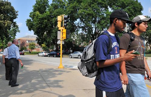 Taurean Willingham, center right, freshman in Business, carries a copy of the New Testament given to him by Paul Otto, center left, of Arthur, Illinois. Erica Magda
