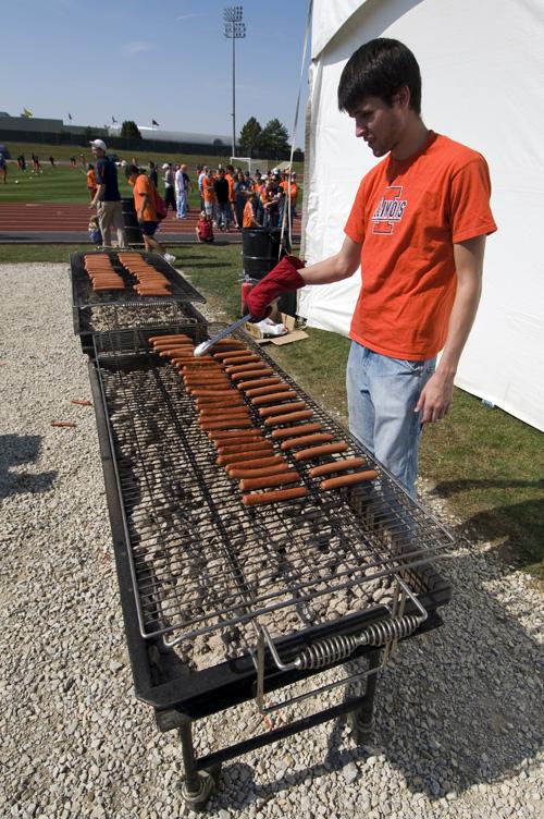 Matt Schutzius, senior in LAS, grills hot dogs to be given away at the Soccerfest on Sunday. Taylor Johnson
