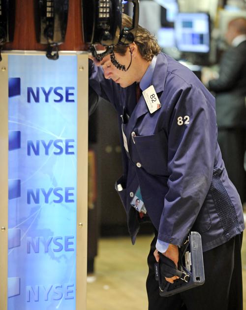 Trader Dudley Devine leans on a phone post on the New York Stock Exchange floor Monday. Wall Street suffered another traumatic session during the day. Richard Drew, The Associated Press

