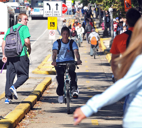 Bicyclists and pedestrians compete for space on the sidewalks lining Wright Street in Champaign. Erica Magda
