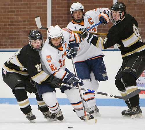 Sophomore Tim Gilbert (10) and senior Jordan Pringle (19) fight off Oakland University defensemen to get to the puck at the Ice Arena on Friday. Erica Magda
