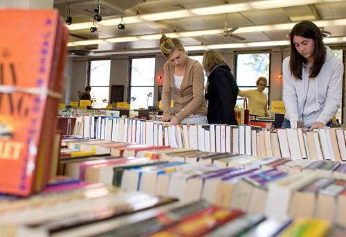 Patricia Mathy (right), senior in LAS, and Molly Schmidt, sophomore in LAS, organize books for sale at the Independent Media Center in Urbana on Thursday. Erica Magda
