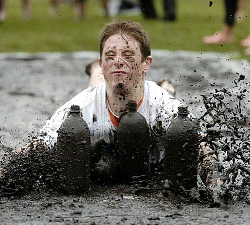 Sean Kearns, formerly a senior in Aviation, scores a strike at the human bowling portion of the Alpha Omega Pi Mud Olympics Sept. 29, 2006. Students who choose to participate in unorganized mud sliding on University property can be charged with property d Erica Magda

