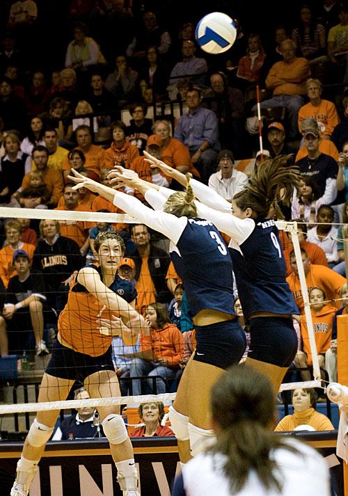 Laura+DeBruler+spikes+the+ball+past+two+Penn+State+players+during+the+volleyball+game+on+Friday%2C+Nov.+14+at+Huff+Hall.+Erica+Magda%0A