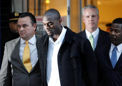 New York Giants wide receiver Plaxico Burress, center, is escorted from a police station in handcuffs in New York on Monday. Burress, who pled not guilty to a weapons possession charge, was fined and suspended from his team on Tuesday. He was placed on th Seth Wenig, The Associated Press
