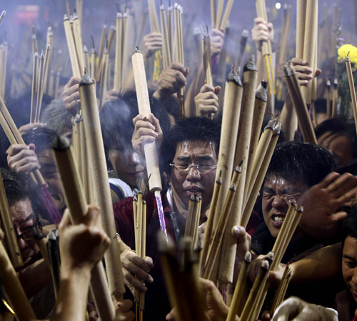 Buddhists rush to stick incense sticks in an urn at a local Chinese Buddhist temple on Monday Jan. 26, 2009 in Singapore. Wong Maye-E, The Associated Press
