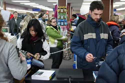 Students purchase books at T.I.S. Bookstore in Champaign on Tuesday. We are having a good book rush, although there is still a long way to go, said Store Manager John Tichenor. Erica Magda
