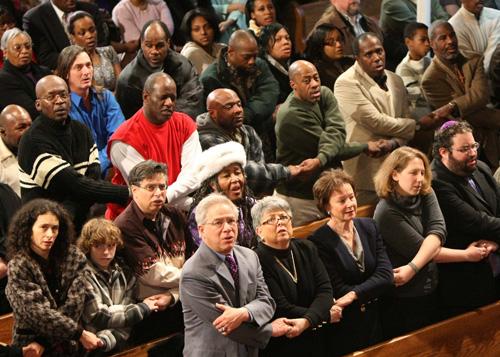 Worshipers of Temple Oheb Shalom and Bethel AME Church hold hands during services at Bethel AME Church in Baltimore on Sunday. Churches across the U.S. celebrated the coming holiday. Luis M. Alvarez, The Associated Press
