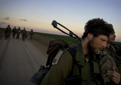 Israeli soldiers leave the Gaza strip after a combat mission Sunday. Gaza Strip militants offered Israel an immediate week-long truce Sunday but conditioned longer-term quiet on a complete Israeli troop withdrawal from the territory. Sebastian Scheiner, The Associated Press
