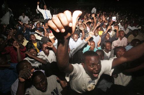 Kenyans react as U.S. President Barack Obama appears on a large screen, as thousands of people in Nairobi, Kenya, gather to watch the U.S. Presidential inauguration ceremony taking place in Washington D.C. on Tuesday. Across Kenya, neighbors divided by po Sayyid Azim, The Associated Press
