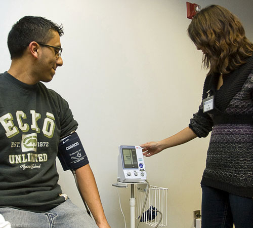 Francisco Villafuerte, junior in FAA, gets his blood pressure checked by Leia Kedem, graduate student in nutritional sciences, in the Wellness Center at the Activities and Recreation Center on Wednesday. The Wellness Center offers free body fat compositio Erica Magda
