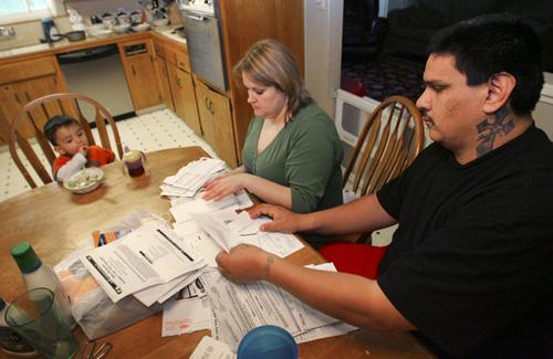 Tanya Duarte and her husband, Fernando, look over bills while their son Jordan looks on, onFeb. 19 in Fresno, Calif. Due to the recession, the Duartes, like many families throughout the country, are close to losing their home. Gary Kazanjian, The Associated Press
