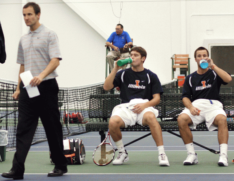 Illinois Ruan Roelofse, a freshman, and Billy Heiser, a junior, take a break between sets after talking with Head Coach Brad Dancer during doubles play at the Illinis meet against Wisconsin on Saturday, Mar. 7, 2009 at Atkins Tennis Center in Urbana.
