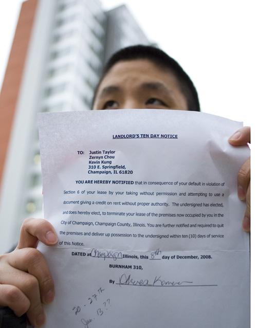 Kevin Kung, junior in LAS, holds his eviction notice outside his apartment at 310 Burnham in Champaign. Kung was evicted because of a conflict with apartment management over a document Kung produced saying that he and his roommates would not have to pay rent until January, even though the three moved in in November. His full address was removed from the image to protect his privacy. Ned Mulka
