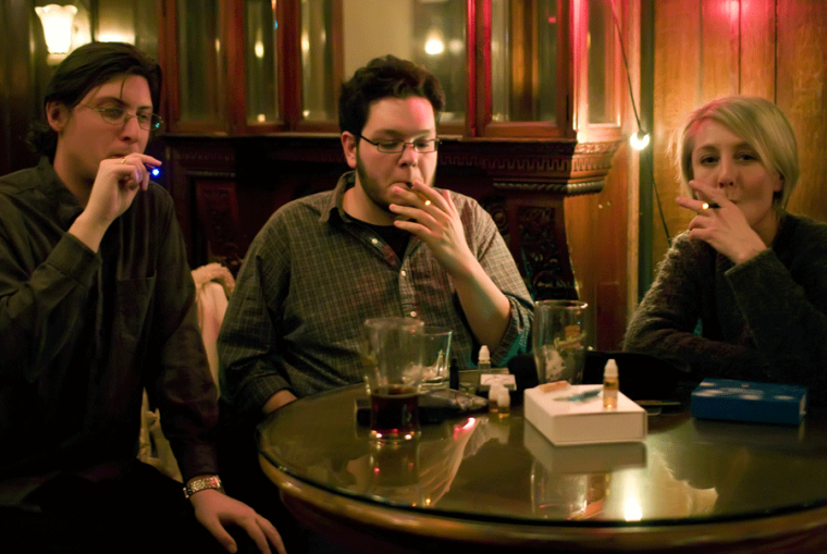 Rrom right to left, graduate students, Benjamin Slade, Matt Garley, and Lisa Pierce demonstrate the use of e-cigarettes at The Blind Pig, a bar in Champaign, on Wednesday, Jan. 28, 2009. E-cigarettes have not yet been approved by the FDA and may be in danger of being outlawed.
