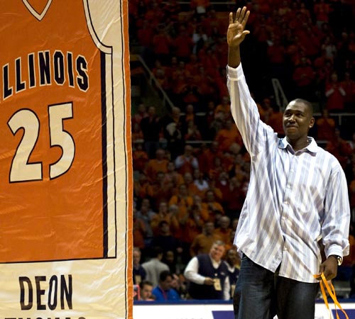 Former Illini basketball player Deon Thomas waves to the crowd after his jersey number is displayed at the Illinois home game against Michigan State at Assembly Hall on Sunday. Brad Meyer
