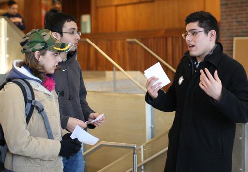 Carlos Rosa (right), a candidate for student senate and sophomore in LAS, speaks to Brittany Hubbard (left) and David Montiel (center), both freshmen in LAS, while passing out fliers near the entrance to the Pennsylvania Avenue Residence Hall dining hall on Monday evening. Trevor Greene
