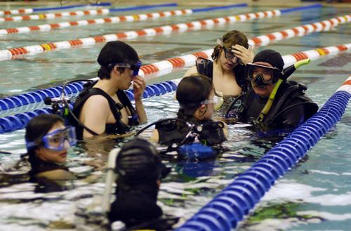 Scuba instructor Brad Knop (right) goes over instructions before taking the class into the deeper section of the pool. Brennan Caughron
