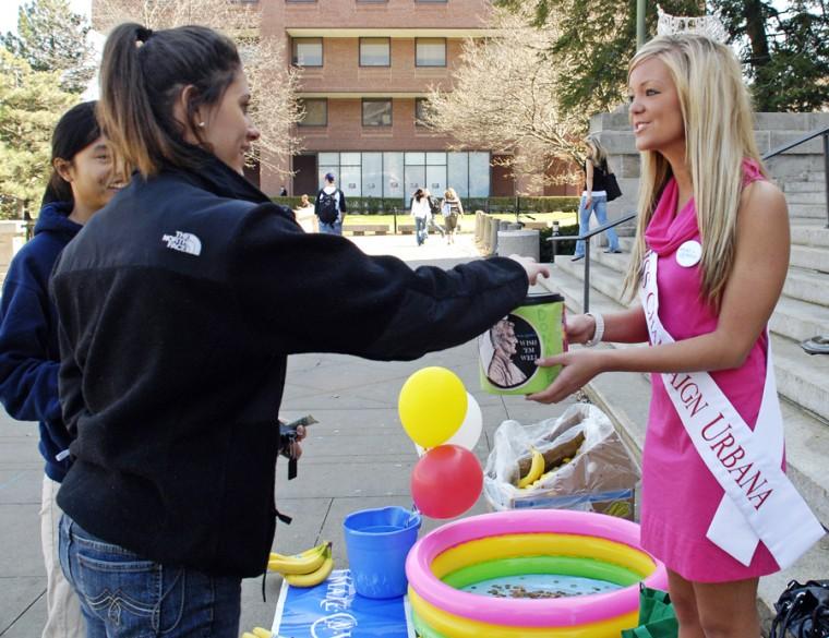 Denise Hibbard, Miss Champaign-Urbana 2009, receives a donation for the Make-A-Wish Foundation from another student. Students who donated received a complimentary banana.
