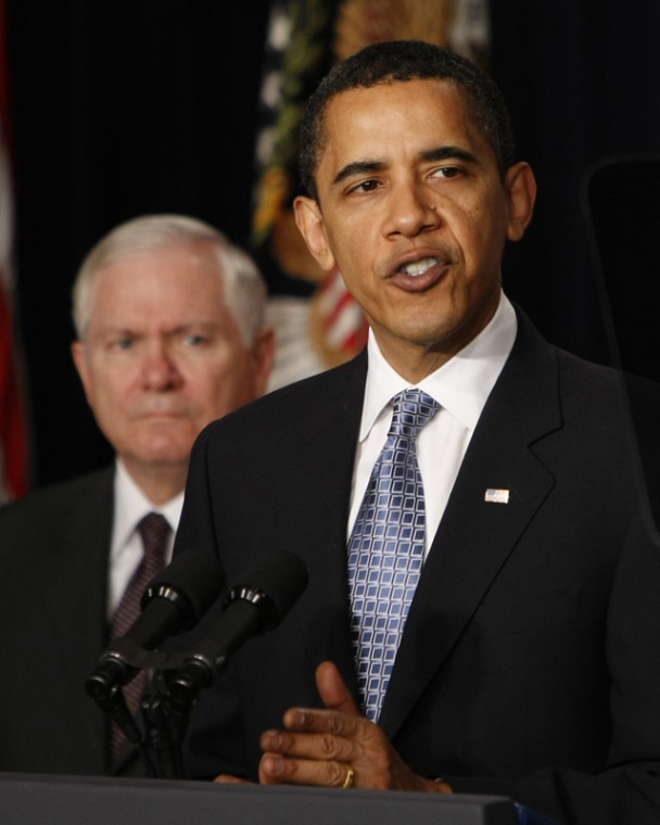 Defense Secretary Robert Gates looks on as President Barack Obama makes remarks on veterans healthcare, Thursday, April 9, 2009, in the Eisenhower Executive Office Building on the White House campus in Washington.
