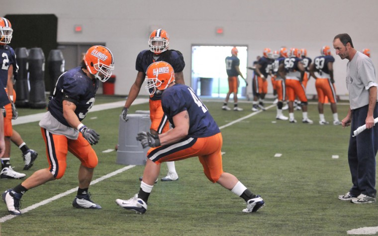 Illinois Ian Thomas (38) and Aaron Gress (42) run drills as Co-Defensive Coordinator Dan Disch watches at Irwin Indoor Athletic Facility on Tuesday, April 7, 2009.
