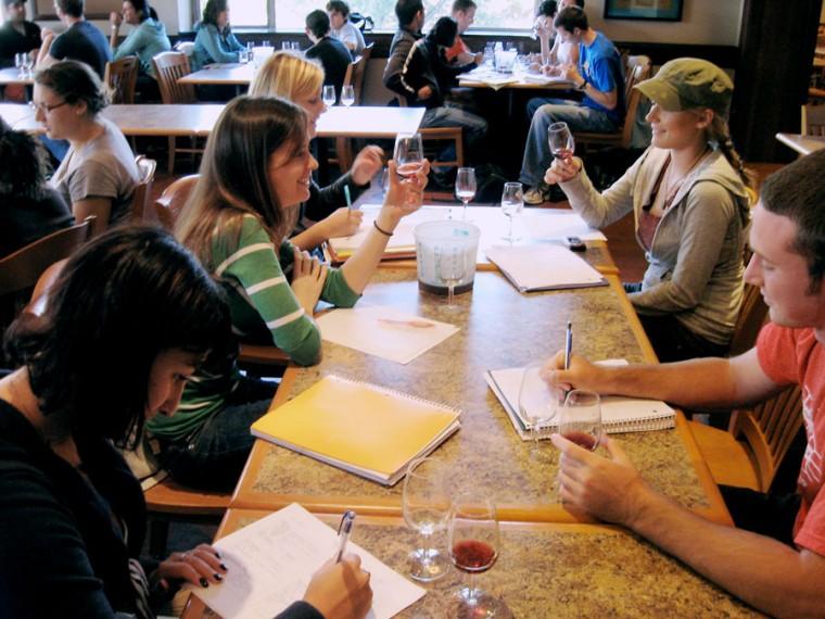 Students+taste+wine+in+Introduction+to+Wine+Science%2C+FSHN+304.+Photo+Courtesy+of+Bradley+Beam.%0A