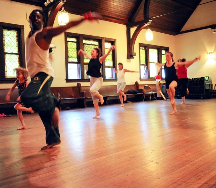 Djibril Camara, left, leads a dance during a West African dance class at the Channing Murray Building in Urbana on Sunday, May 24.
