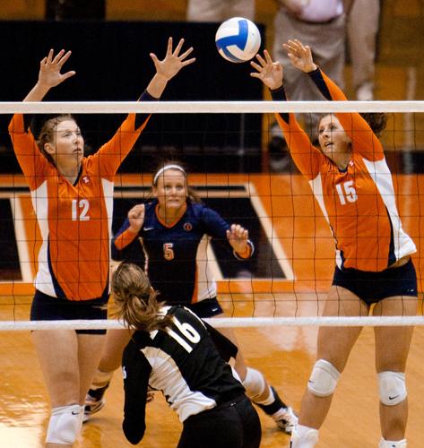 Illinois’ Erin Johnson (12) and Kylie McCulley (15) attempt to block a hit by a Purdue opponent at Huff Hall on Friday, Oct. 9. Up next, the Illini will host Iowa on Nov. 20.
