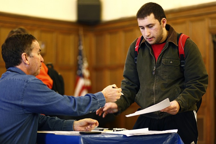 Tasos Kapsalis, sophomore in LAS, receives his ballot from election judge Michael Brandt at the University YMCA in Champaign on Tuesday.
