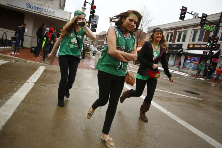 An Unofficial reveler tries to keep warm while walking down Green St. on Unofficial on Friday, March 1, 2013.