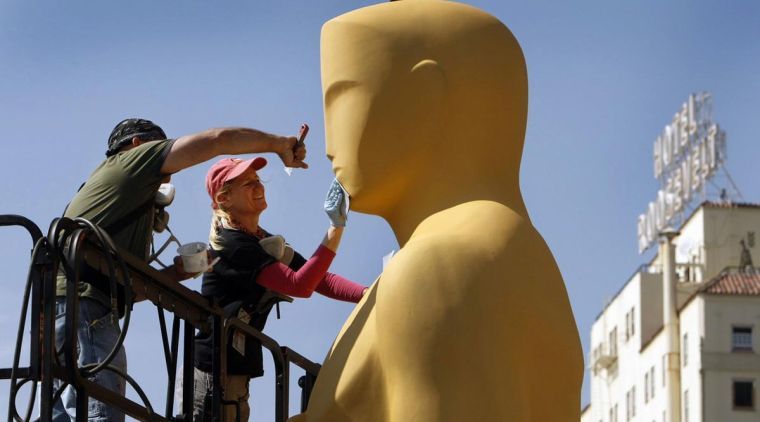 Lead scenic artist Dena DAngelo, right, with scenic artist Rick Roberts use sand paper to prepare the giant Oscar statue for gold paint before he is loaded to the red carpet outside the Dolby Theater at Hollywood and Highland on  Feb. 25 for the Oscars which will be televised live this Sunday, March 2. 
