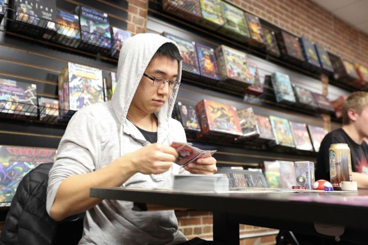 Christopher Zhang a sophomore in Business, plays a round of Magic: The Gathering at the Gaming Goat in Champaign.
