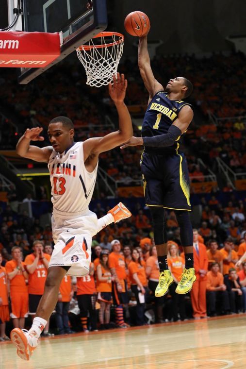 Illinois Tracy Abrams (13) dunks under Michigans Glen Robinson III (1) during their game at State Farm Center, on Tuesday, March 4. The Illini lost 84-53.