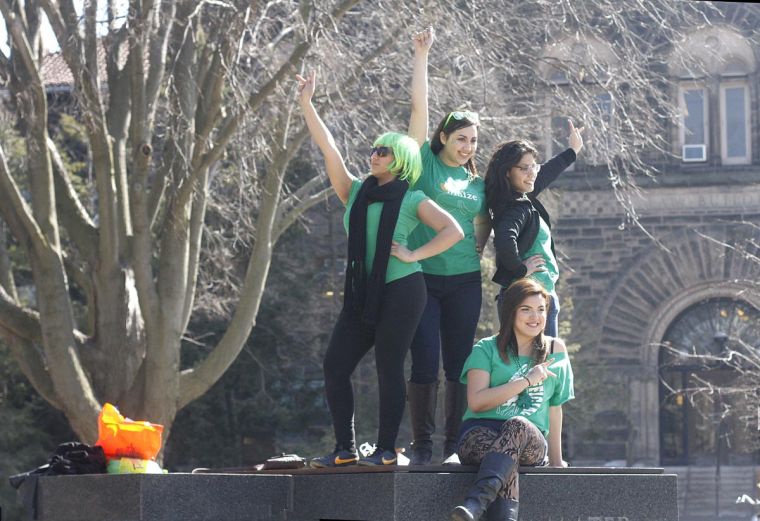 Students and alumnae pose on top of the Alma Mater during Unofficial festivities on Friday. 